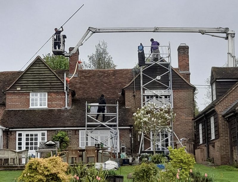 The Moss Cleaners using cherry picker and scaffolding to clean roof safely and professionally in Hook, Hampshire